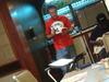 Another angle of a man in red near the dinning table