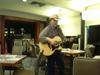 Another angle of man holding a guitar